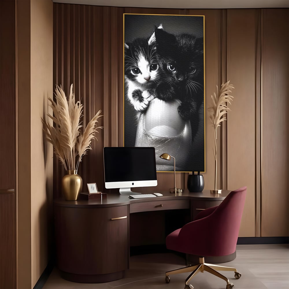 Tablou canvas cu tablou canvas cu doi pisoi mici agatati de un deget, in rama de aluminiu auriu, pe perete intr-un birou